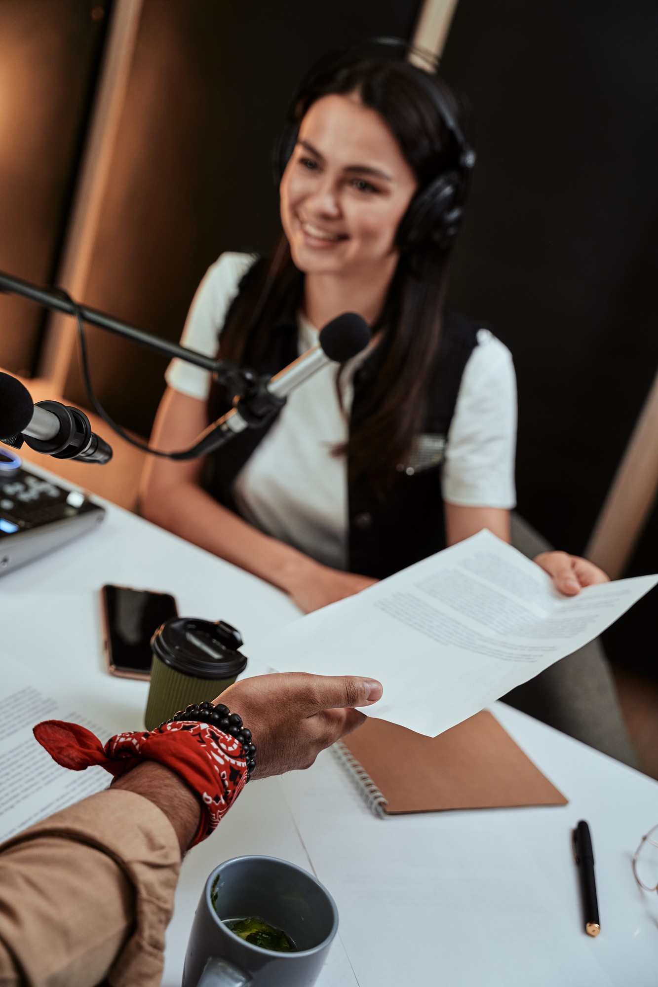 A podcast host recording at a mixing desk with a boom microphone